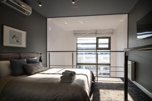 a bedroom with a bed and a large window at Qbik Loft Modern Apartment in Warsaw