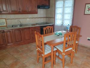 una cucina con tavolo in legno e 4 sedie di Casa Rural Domingo Pio a Echedo