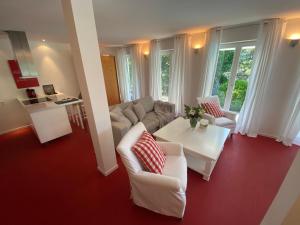 a living room with a couch and a table at Landhaus am Plattenbichl - Luxus Apartment mit Privat-Pool und Sauna - im Sommer Bergbahn inklusive in Oberstdorf