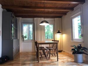 ein Esszimmer mit Tisch und Stühlen und zwei Fenstern in der Unterkunft Dom Blisko Natury Osłonin in Osłonin