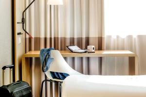 a room with a desk with a phone and a chair at ibis Hotel Berlin Mitte in Berlin