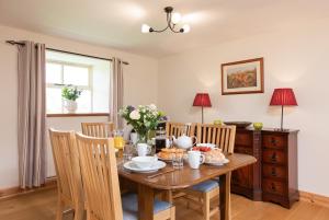 a dining room with a wooden table and chairs at HayburnbeckFarm in Scarborough