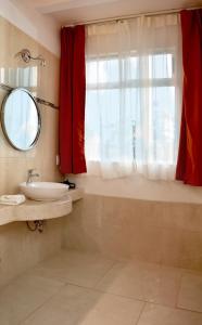 a bathroom with a sink and a mirror and a window at Best Western Tamarindo Vista Villas in Tamarindo