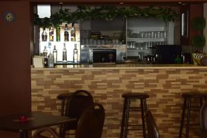 un bar en un restaurante con mesas y taburetes en Hotel Hellinis, en Florina