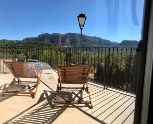 two chairs and a table on a balcony with a view at Chez Chloe in Murillo de Gállego