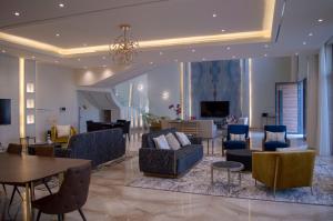 Luxurious villa في الرياض: غرفة معيشة مع أريكة وكراسي وطاولة