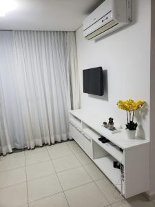 uma cozinha branca com um balcão branco e uma televisão em Carneiros Beach Resort - Apto 214D em Tamandaré