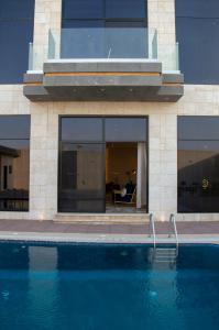Luxurious villa في الرياض: مبنى فيه مسبح امام مبنى