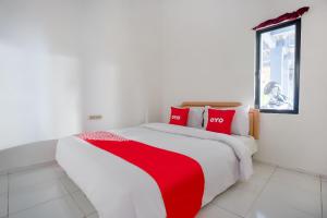 a bedroom with a large bed with red pillows at OYO 3728 Tunas Plaza Residence in Bekasi