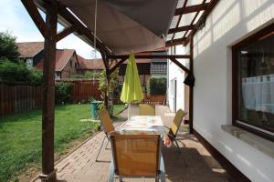un patio con mesa, sillas y sombrilla en Ferienwohnung Mira, en Grebendorf
