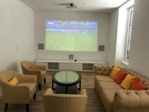 a living room with a tv and a couch and chairs at Écrin Haut de Gamme possibilité jacuzzi Hamam in Clermont-Ferrand