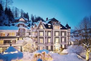 une grande maison recouverte de neige la nuit dans l'établissement ERIKA Boutiquehotel Kitzbühel, à Kitzbühel