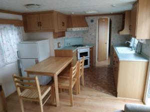 a kitchen with a table and chairs and a refrigerator at 4U Pokój w domku holenderskim Rooms in Tinyhouse in Zgorzelec