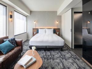 una camera d'albergo con letto e divano di THE LIVELY HONMACHI OSAKA / Vacation STAY 76687 ad Osaka