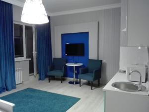 baño con 2 sillas, mesa y TV en Апартаменты на набережной 15 этаж, en Astana