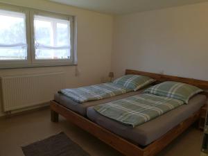 2 Einzelbetten in einem Zimmer mit 2 Fenstern in der Unterkunft Ferienhof Schmid in Salem