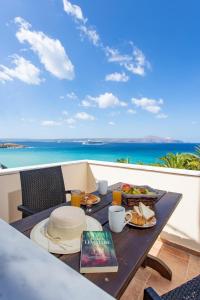 a table on a balcony with a view of the ocean at Manos Apartments in Almyrida