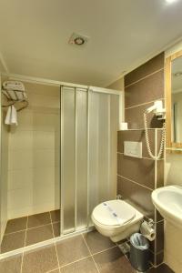 a bathroom with a shower and a toilet and a sink at Antroyal Hotel in Antalya