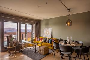 a living room with a yellow couch and a table at Riddertunet Leiligheter in Beitostøl