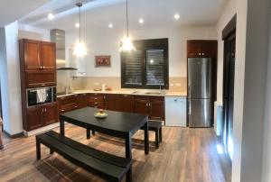 a kitchen with a table and a kitchen with a refrigerator at Chez Chloe in Murillo de Gállego