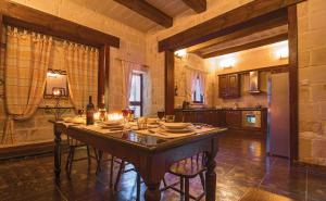 una cocina con una gran mesa de madera en una habitación en Villa Sky, en Żejtun