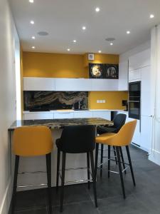 a kitchen with yellow and white cabinets and a table and chairs at Écrin Haut de Gamme possibilité jacuzzi Hamam in Clermont-Ferrand