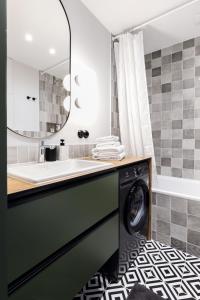 a bathroom with a washing machine and a mirror at Old-New Apartment in Central Kaunas in Kaunas