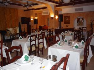 un comedor con mesas y sillas con mantel blanco en Hotel Sud, en Giurgiu