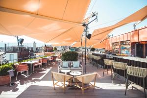 a rooftop patio with tables and chairs and umbrellas at Storchen Zürich - Lifestyle boutique Hotel in Zurich