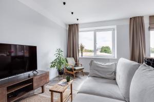 a living room with a couch and a flat screen tv at Old-New Apartment in Central Kaunas in Kaunas