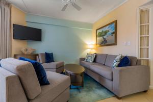 a living room with two couches and a flat screen tv at Playa Linda Beach Resort in Palm-Eagle Beach