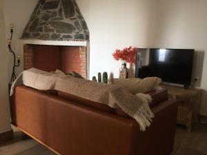 uma sala de estar com um sofá castanho e uma lareira em Lambisco- Alojamento local em Alfândega da Fé