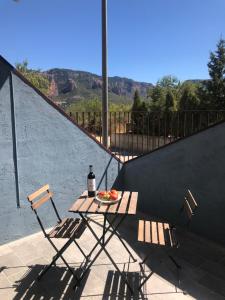 uma mesa com uma garrafa de vinho e duas cadeiras em Chez Chloe em Murillo de Gállego