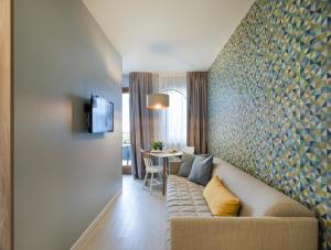 a living room with a couch and a table at Hatelier Garda Home by Enjoy Garda Hotel in Peschiera del Garda
