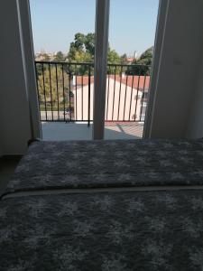 a bedroom with a bed and a view of a balcony at Apartman Djukic in Šabac