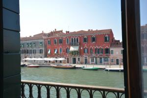 una vista da una finestra di un canale con barche di Venezia Canal View a Venezia