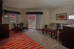 a living room with a couch and a table and chairs at Holiday Inn Express & Suites Naples Downtown - 5th Avenue by IHG in Naples
