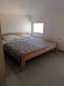 a large bed in a bedroom with a window at Apartman Djukic in Šabac