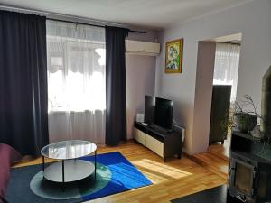 a living room with a table and a tv at Park apartment in Kaunas