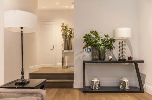 a living room with a lamp and a table with plants at Chancery Quarters - 124 Chancery Lane in London +101 photos