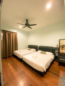 two beds in a room with a ceiling fan at Maison life 小居屋 The Loft Imago in Kota Kinabalu