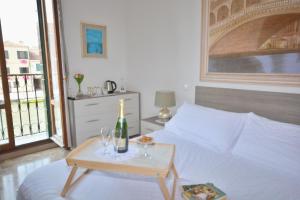 Un dormitorio con una cama y una mesa con una botella y vasos. en Venezia Canal View en Venecia