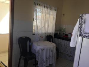 Apto Praia de Setiba 2 في غواراباري: مطبخ صغير مع طاولة و كرسيين