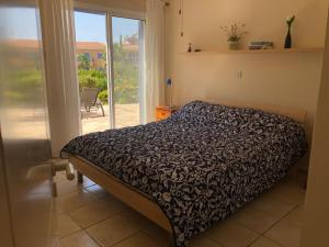a bedroom with a bed and a sliding glass door at Limnaria Villas - comfy 2 bed, 2 bath ground floor apartment in Paphos