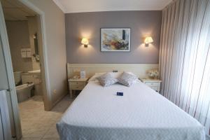 a bedroom with a white bed and a bathroom at San Marcos Salnés in Cambados +15 photos