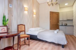 niewielka sypialnia z łóżkiem i stołem oraz kuchnia w obiekcie KUBU Loft w Kłajpedzie