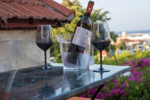 two wine glasses and a bottle of wine on a table at Casa de Mikel in Rhodes Town