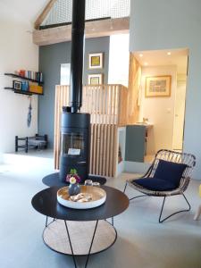 uma sala de estar com um fogão e 2 cadeiras em La Maison de Madame Baudy em Giverny