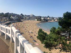 Un grupo de personas en una playa cerca de una valla blanca. en La Marandière, en Saint-Quay-Portrieux