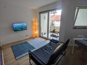 ein Wohnzimmer mit einem Bett und einem großen Fenster in der Unterkunft Ideales Messe Appartment 15min Fahrtweg in Kirchheim unter Teck